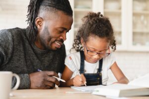 Father helping daughter with schoolwork