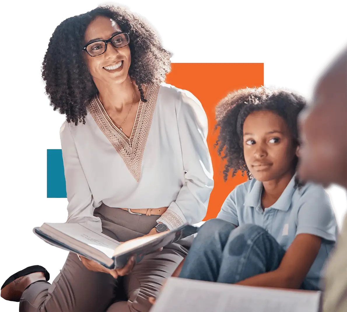 Smiling Black female schoolteacher sitting next to a student of color looking and listening intently.