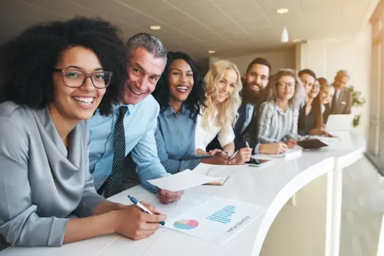 A group of diverse district leaders lined up smiling, looking at data in an infographic.